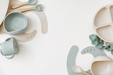 Baby Table Setting Background. Silicone set on light background. Place for text, copy space. Top view, flat lay.