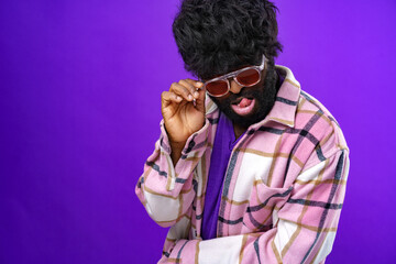 Fashion portrait of african american man in glasses against purple background