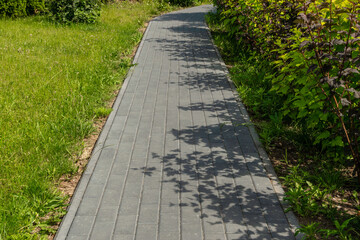 Footpath with grass texture background, paved path pattern