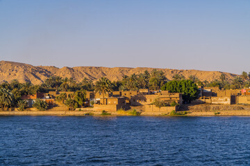 Panoramic view of houses in a traditional village at sunset on the Nile River near Edfu, Egypt