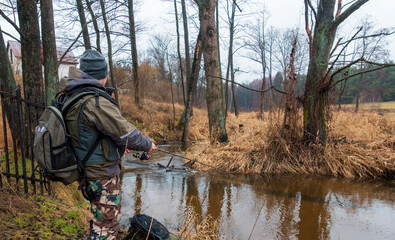 An angler catches trouts on a small beautiful river