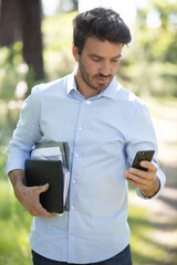 portrait of young businessman talking on cell phone in park