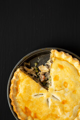 Homemade Chicken Pot Pie on a black surface, top view. Flat lay, overhead, from above. Copy space.