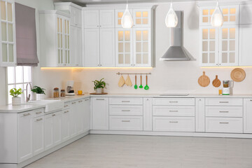 Fototapeta premium Light kitchen interior with stylish furniture and modern equipment