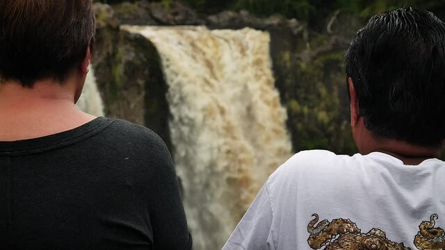 People looking at Rainbow Falls, Big Island of Hawaii. Mid angle, parallax movement, slow motion, HD.