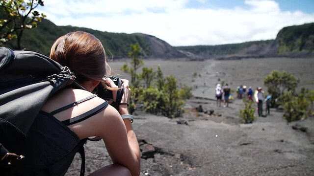 Woman photographing in Kilauea Iki Crater, Big Island of Hawaii. Mid angle, parallax movement, slow motion, HD.