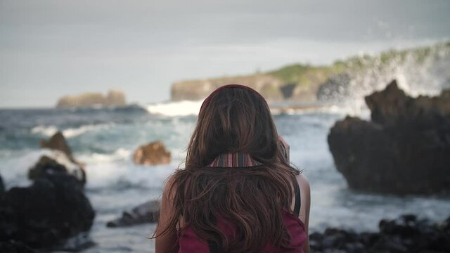 Woman photographing dramatic coastline in Keanae Peninsula, Maui, Hawaii. Mid angle, parallax movement, slow motion, HD.