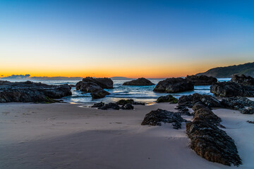 Fototapeta na wymiar Sunrise seascape and a rocky beach