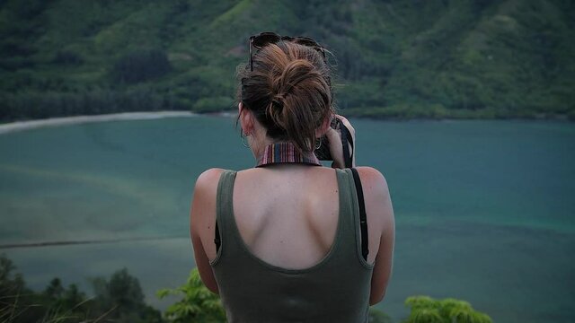 Woman photographing in Crouching Lion Lookout, O'ahu, Hawaii. Mid angle, parallax movement, slow motion, HD.