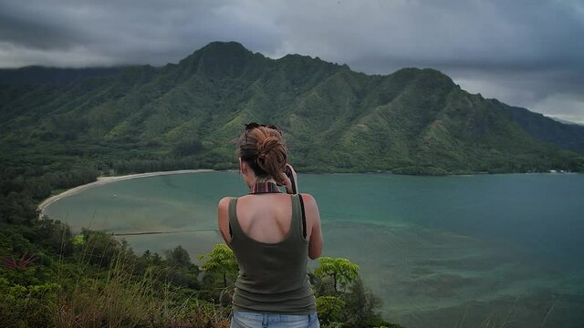 Woman photographing in Crouching Lion Lookout, O'ahu, Hawaii. Mid angle, parallax movement, slow motion, HD.