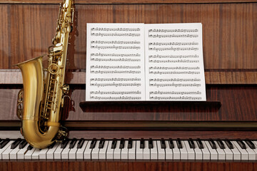 Beautiful saxophone on piano keys. Musical instruments