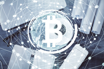 Blockchain theme hologram drawings over computer on the desktop background. Top view. Multi exposure. Concept of cryptoeconomy.