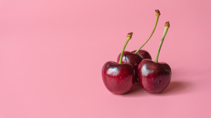 three heart shaped cherry berries isolated on pink background cutout