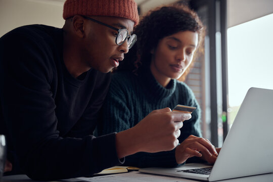 Close up of mixed race couple using laptop for online shopping. Happy African American couple using credit card for online banking. High quality photo