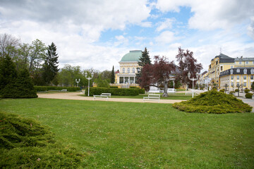 Fototapeta na wymiar Spa promenade with flower bed in front of Glauber mineral springs building 