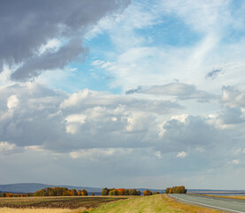 panorama of fantastic sky with old asphalt highway. country road leads through the fields. Countryside road in siberia. copy space