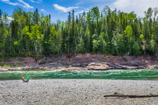 Tourists picnicking on the rocky beach of the Malin, a meander of the Bonaventure river, famous for its crystal blue waters  in Quebec (Canada)