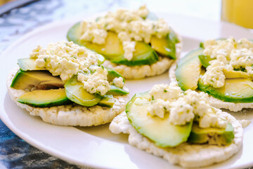 Puffed wheat toast with avocado and fresh cheese with olive oil and parsley.