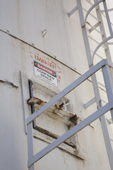 a red, black and white metal Danger Confined Space warning sign on a structure exterior wall