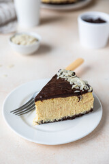 Delicious creamy cheesecake decorated with chocolate glaze and almond, light concrete background. No bake mousse dessert.