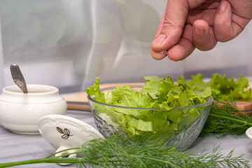 the cook prepares the salad and salts it with salt