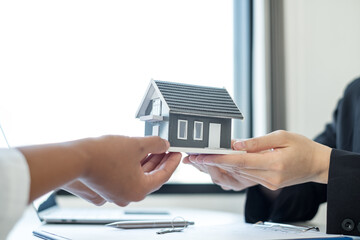 Real estate agent broker hand over the home to the new owner after completing the signing according...