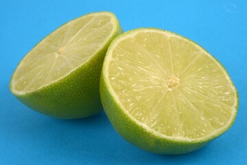 Citron vert coupé en deux en gros plan sur fond bleu