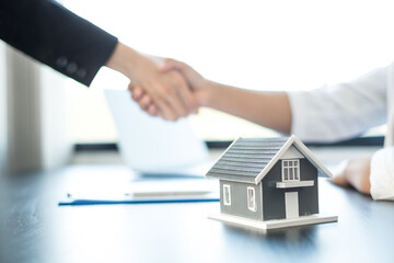 Fototapeta na wymiar Businessmen and brokers real estate agents shake hand after completing negotiations to buy houses insurance and sign contracts. Home insurance concept