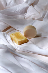 natural cosmetics, hygiene and beauty concept - bar of craft soap on white sheet