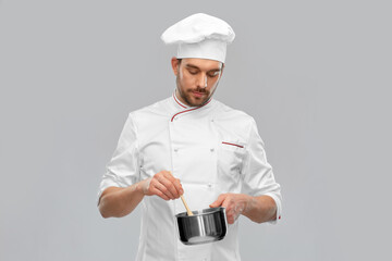 cooking, culinary and people concept - male chef in toque with pot or saucepan over grey background