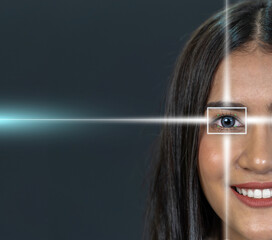 Eye scanning of asian young woman by laser light over the dark background, vision and identification concept
