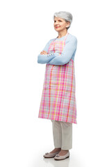 cooking, culinary and old people concept - portrait of smiling senior woman in kitchen apron with crossed arms over white background