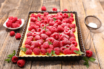 raspberry tart with cream on wood background