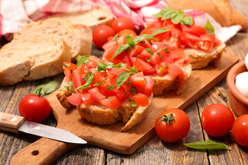 Fototapeta na wymiar preparation of bruschetta with tomato and basil