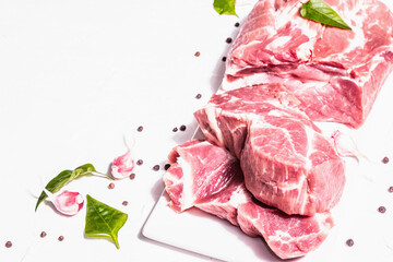 Raw pork meat, sliced cuts with dry sumac, fresh garlic and basil leaves
