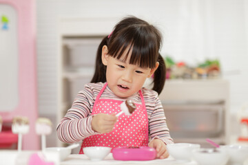 young  girl pretend play food preparing at home