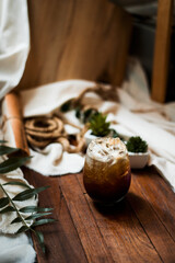iced coffee in iridescent stemless glass served on black table at cafe​