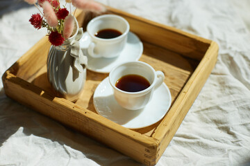 Breakfast in bed, try with two cups coffee and flower in sunlight at home, chambermaid bringing tray with breakfast in hotel room, good service