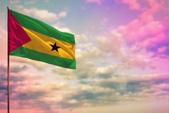 Fluttering Sao Tome and Principe flag mockup with the space for your content on colorful cloudy sky background.
