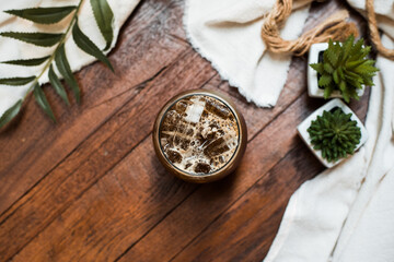 iced coffee in iridescent stemless glass served on black table at cafe​