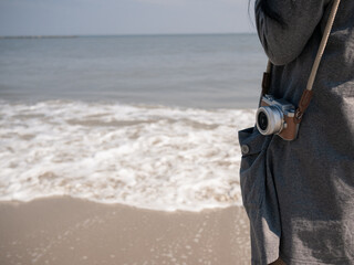 crop photo of person with camera on beach