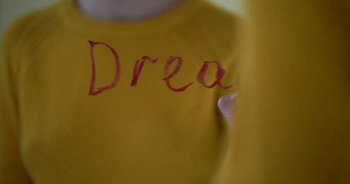 Woman hand writing word ugly by red lipstick mirror glass, young age criticism