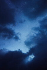 Night sky with the moon framed by clouds 