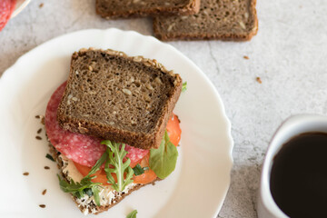 Cooked breakfast with coffee and sandwich. All this on a gray background