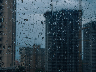 Raindrops on window. wet window city lights rain drops, abstract background autumn winter glow glass