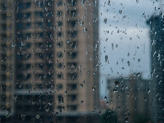 Raindrops on window. wet window city lights rain drops, abstract background autumn winter glow glass