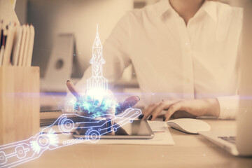Double exposure of creative hologram and woman holding and using a mobile device. Start up concept.