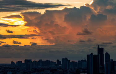 Fototapeta premium The blurred abstract background of the morning sun exposure to the tiny dust particles that surround the tall buildings in the capital, the long-term health issue of pollution