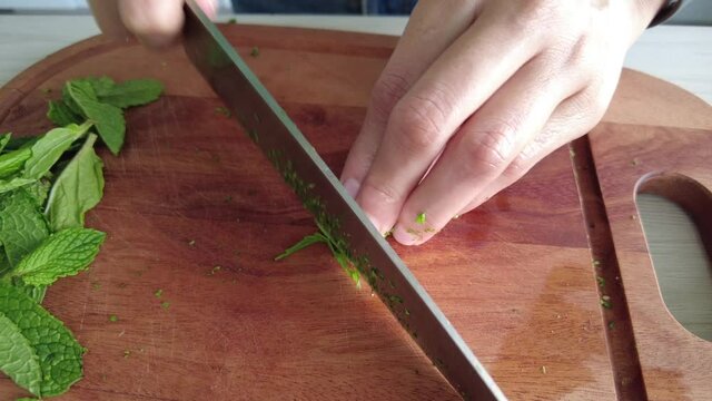 woman chopping mint to prepare tabbouleh