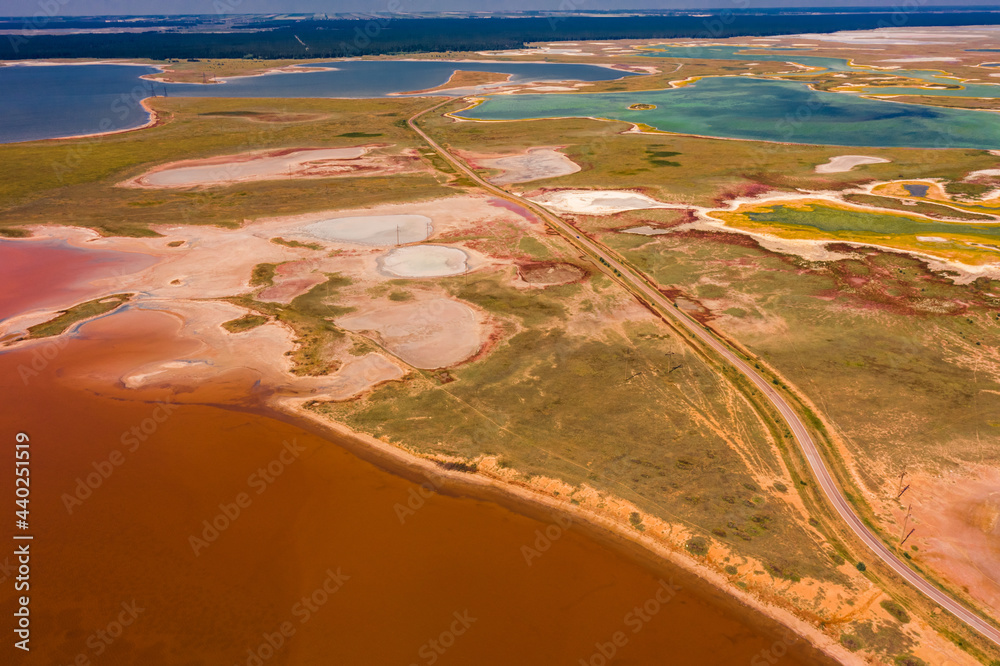 Sticker Aerial view of a road amid a crimson salt lake and other small lakes in Altai